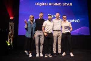 Tím Signity na pódiu pred veľkou obrazovkou, kde je nápis Digital RISING STAR